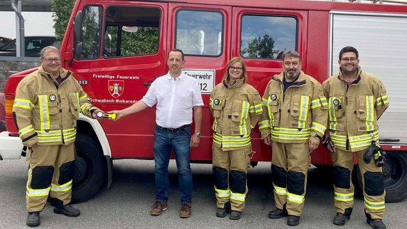 Feuerwehrleute vor einem Feuerwehrfahrzeug