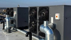 Auf dem Dach sind große Klimaanlagen mit mehreren Ventilatoren und Rohren zu sehen, die für die Luftzirkulation sorgen.