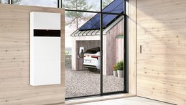 Ein Holzhaus mit einer Photovoltaikanlage und einem E-Auto und einer Wallbox von Vissmann
