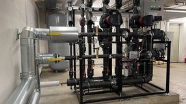 Eine komplexe Rohrleitungsanlage mit verschiedenen Pumpen und Druckmessgeräten in einem industriellen Raum.